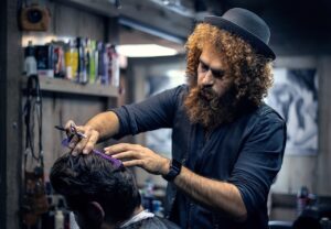 Blog Peluquero canino trabajando con un caniche de pelo rizado sobre mesa de peluquería
